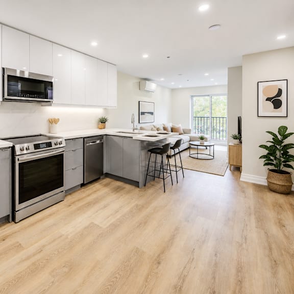 a modern kitchen with wooden floors and stainless steel appliances.