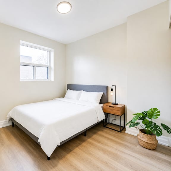 a bedroom with a white bed and a window.