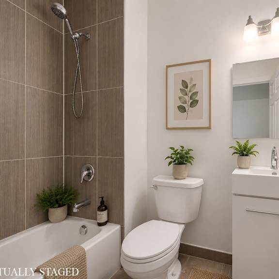 a white bathroom with a toilet, sink, and a plant.