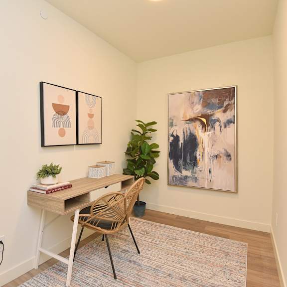a room with a desk and chair in front of a painting at roxy apartments, hamilton