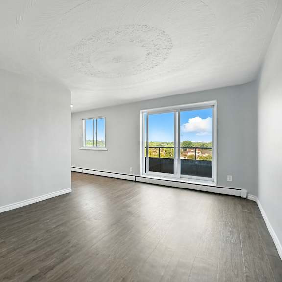 a spacious room with a view of the sky through the windows.