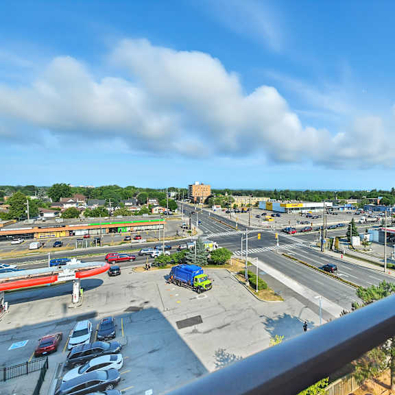 a view from a balcony overlooking a busy parking lot and road.