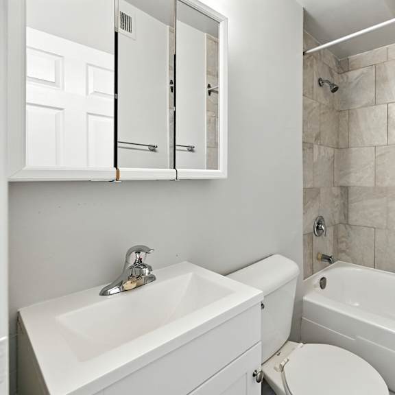 a white bathroom with a sink, toilet, and bathtub.