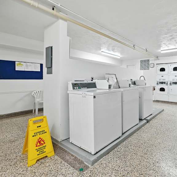 a yellow caution sign is on the floor next to a white piece of equipment.