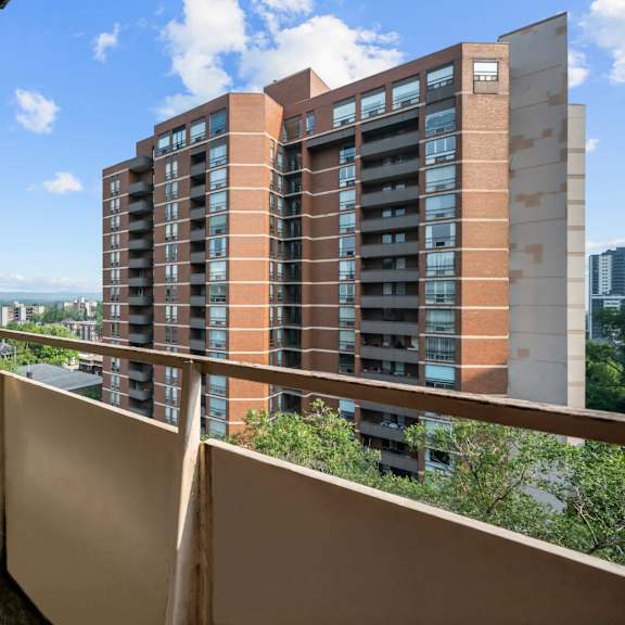 a long balcony with a building in the background.