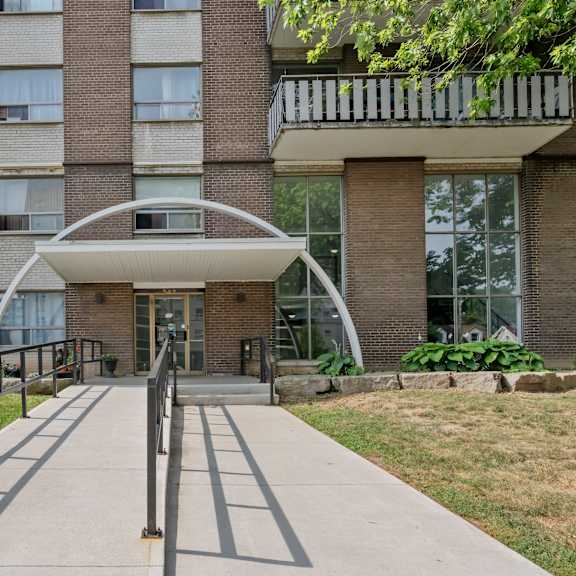 a modern building with a white arched entrance and a metal railing.