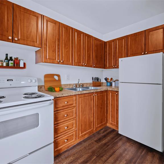 a kitchen with white appliances and wooden cabinets.