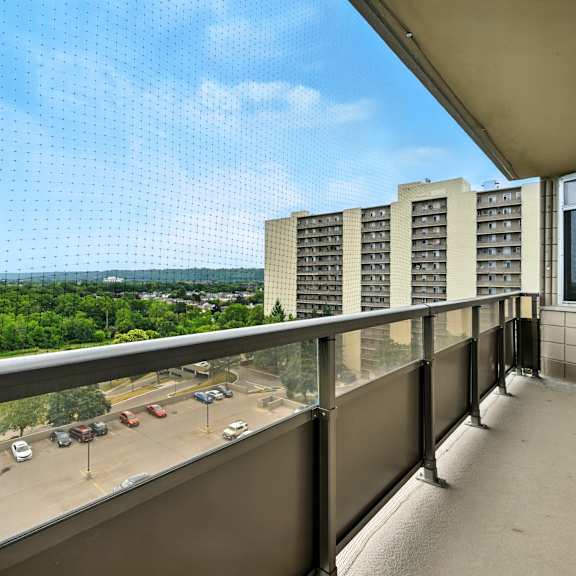 a balcony with a view of a highway and trees.