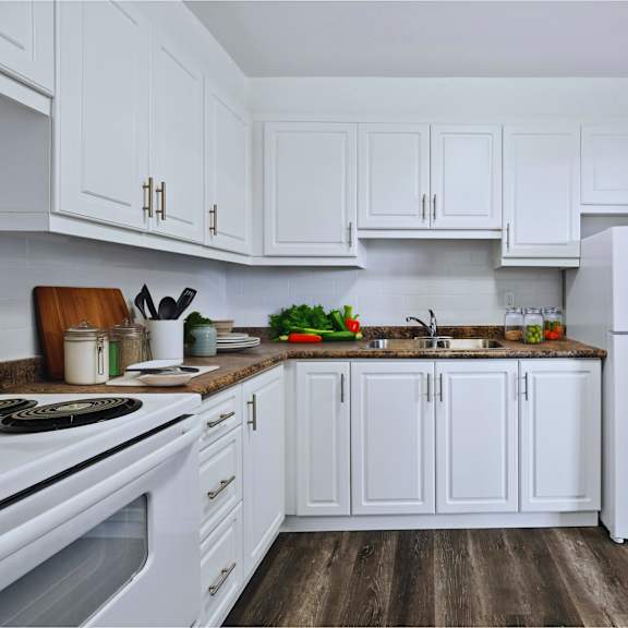 a white kitchen with a white fridge and white cabinets.