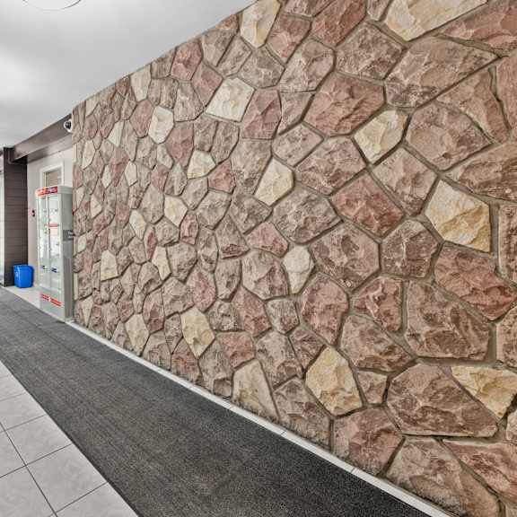 a hallway with a stone wall and tiled floor.