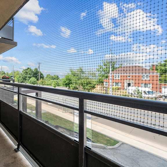 a balcony with a black railing and a brick wall.