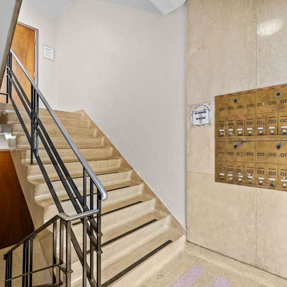 a staircase with a metal railing and a wall with a bunch of buttons on it.