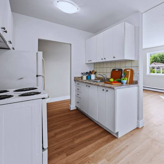 a kitchen with white cabinets and a white stove.