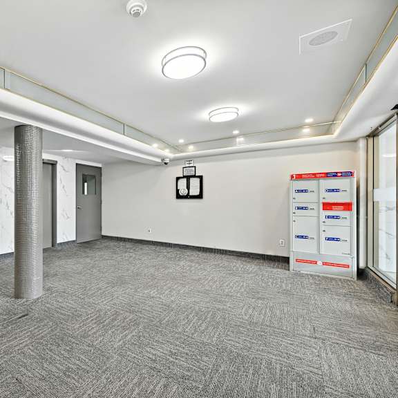 a room with a grey carpet and white walls with a white ceiling and a white door.