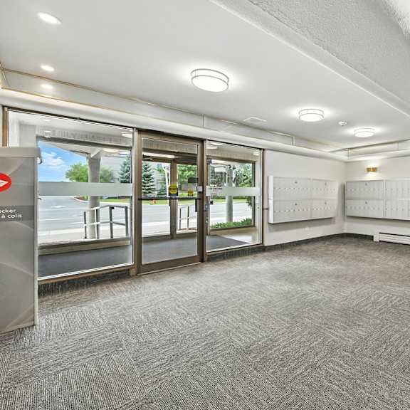 a hallway with a grey carpet and a white ceiling.