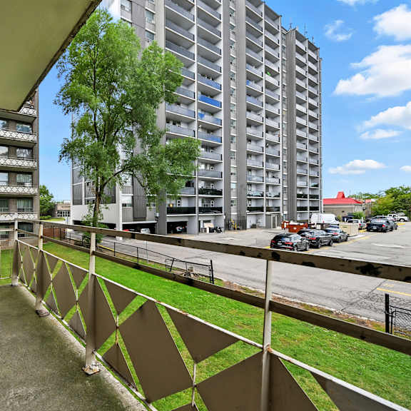 a view of a balcony with a metal railing and a building in the background.