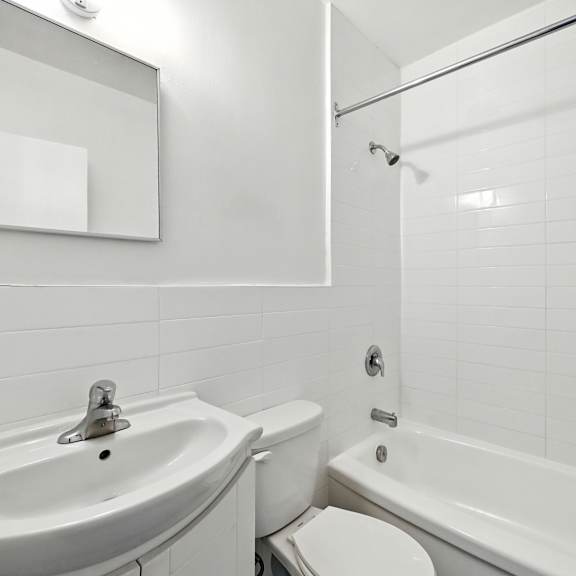 a white bathroom with a sink, toilet, and bathtub.