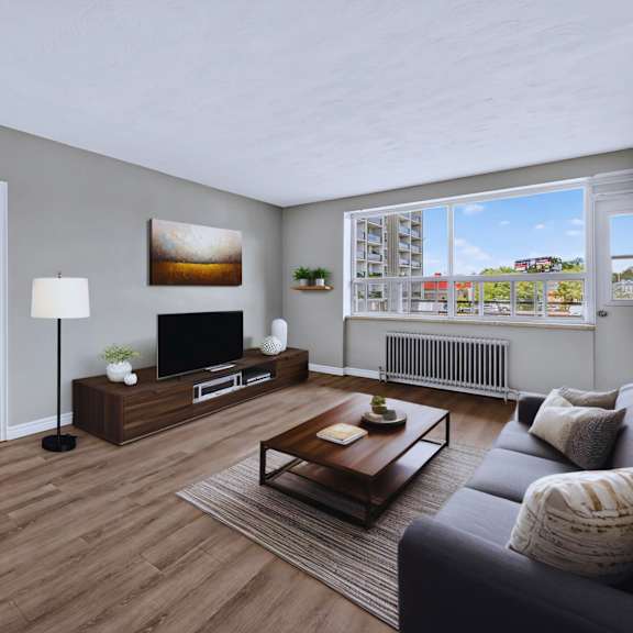 a living room with a grey couch, a wooden coffee table, and a television on a stand.