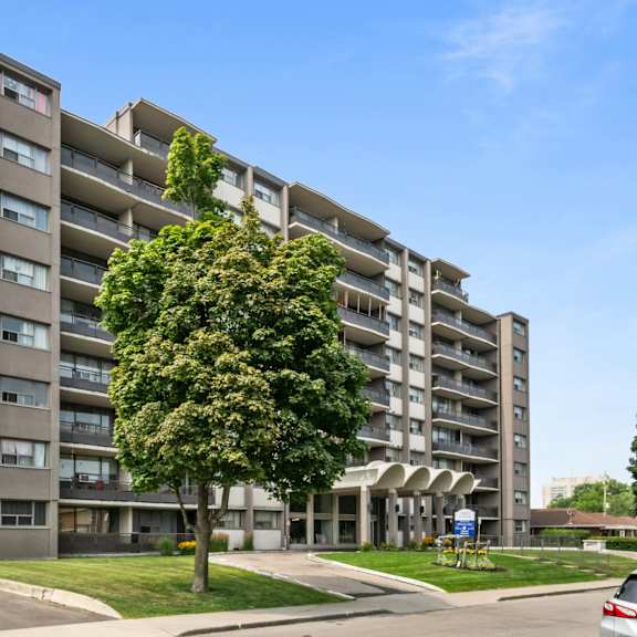 a large apartment building with a tree in front of it.