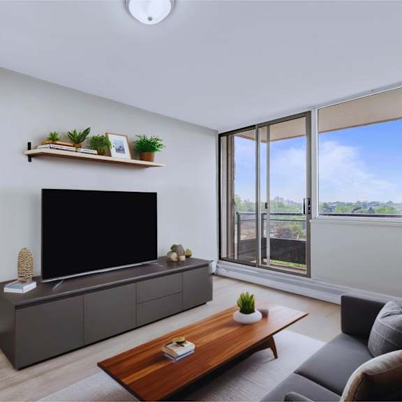 a modern living room with a grey sofa, a wooden coffee table, and a flat-screen tv.