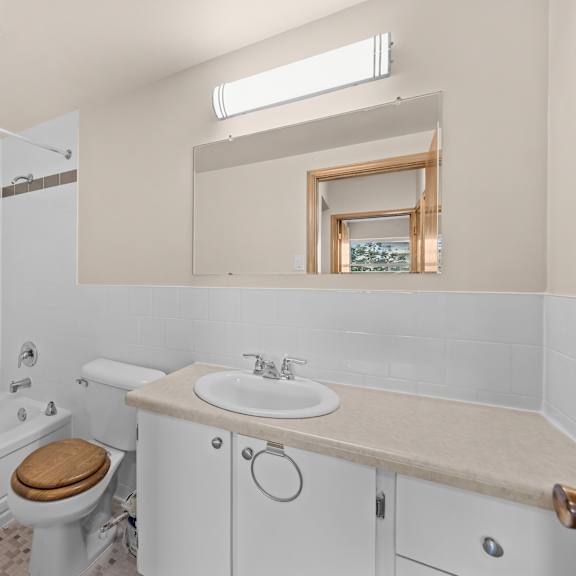 a white bathroom with a toilet, sink, and tub.