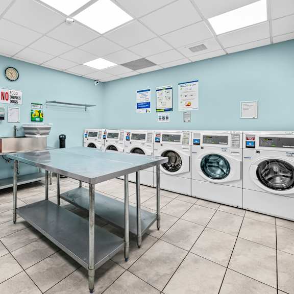 a laundromat with a row of washers and dryers.