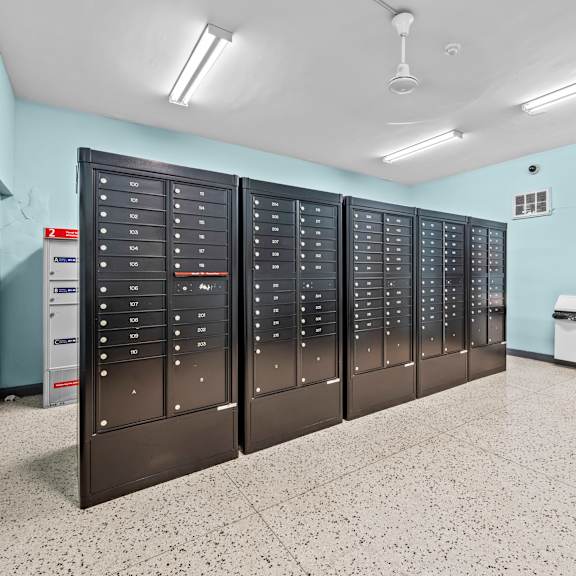 a row of black lockers in a room with a white floor.