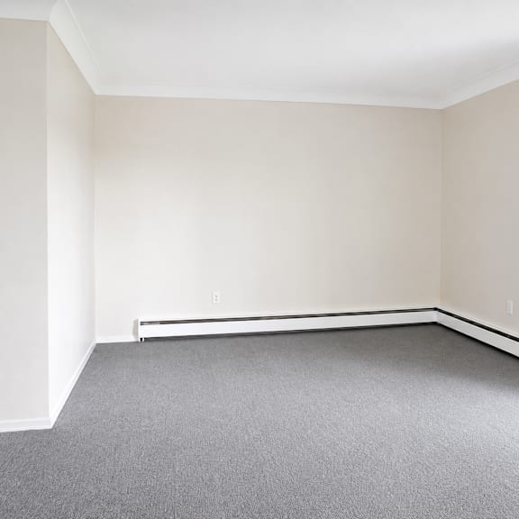a room with a grey carpet and white walls.