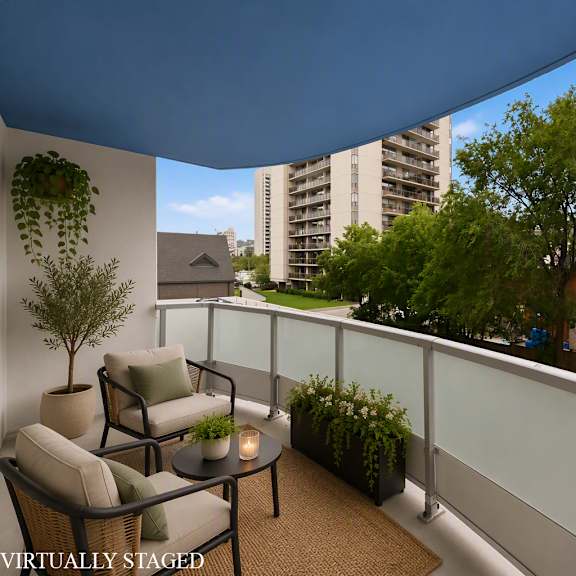 a balcony with a table and chairs overlooking a street.