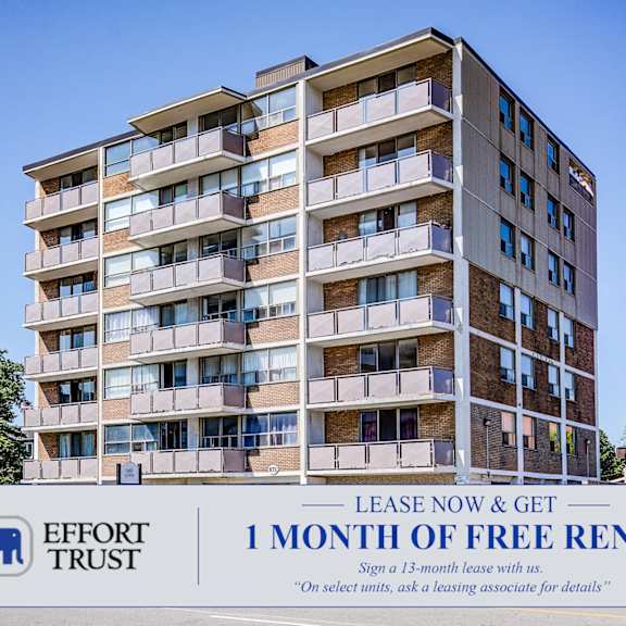 a tall apartment building with a sign offering a free month of rent.