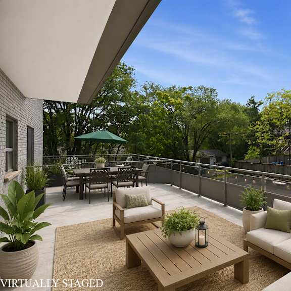 a patio with a couch, chairs, and a table with a potted plant on it.