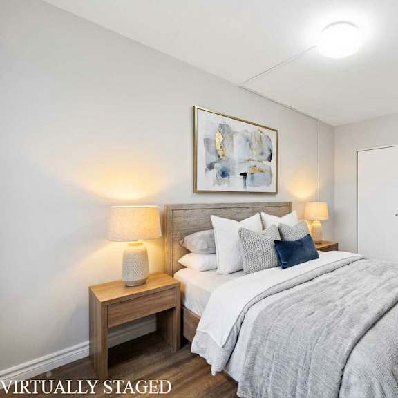 a bedroom with a bed, nightstands, and a painting on the wall.