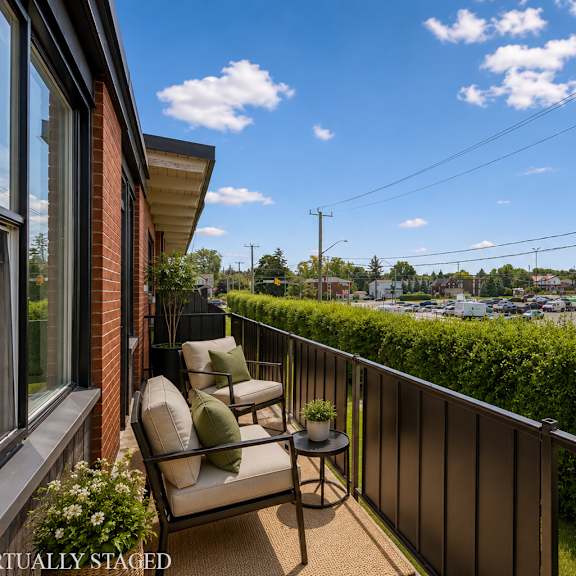 a balcony with a chair and table overlooking a parking lot.