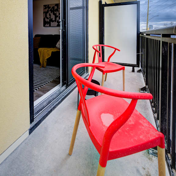 a red chair sits on a balcony at the maverick apartments, ontario, n2h 0e3