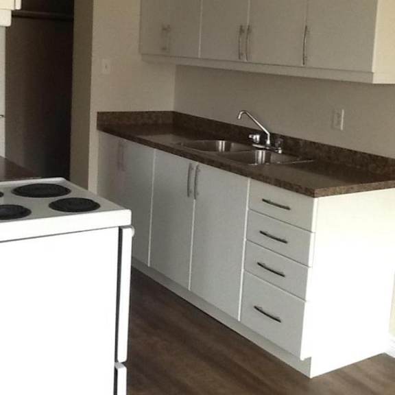a kitchen with white cabinets and a white stove.