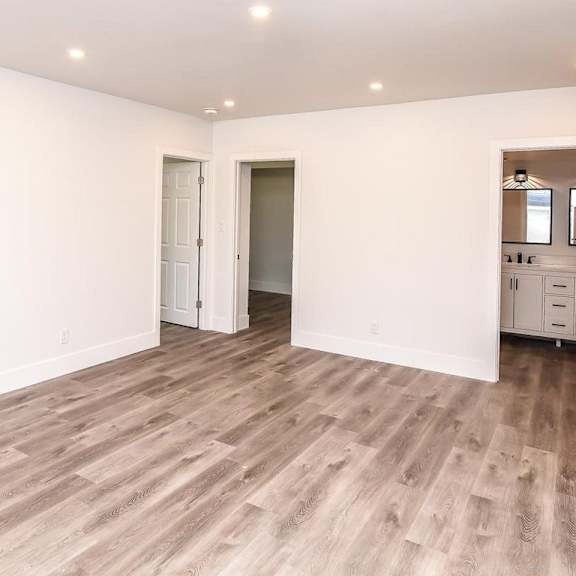 a room with wooden flooring and white walls.