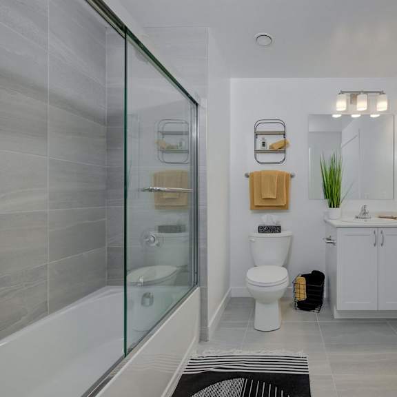 bathroom with a glass shower enclosure at the maverick apartments, kitchener, ontario