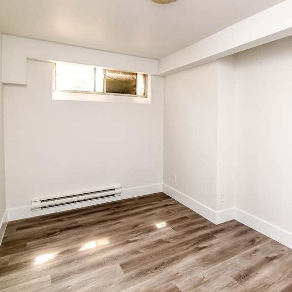 a room with wooden flooring and a window.