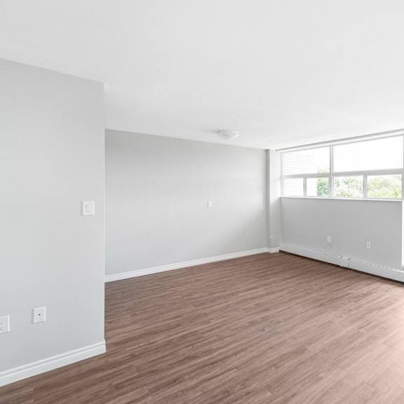 a room with wooden flooring and large windows.