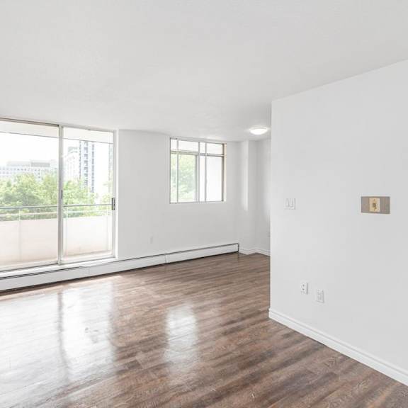 a large empty room with wooden floors and white walls.
