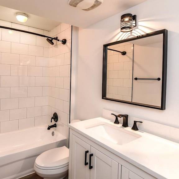 a white bathroom with a toilet, sink, and tub.