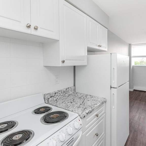 a kitchen with white cabinets and a granite countertop.