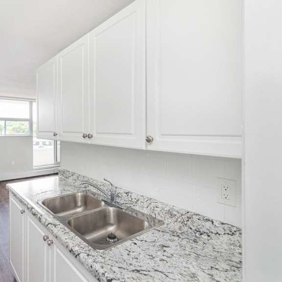 a kitchen with a granite countertop and white cabinets.
