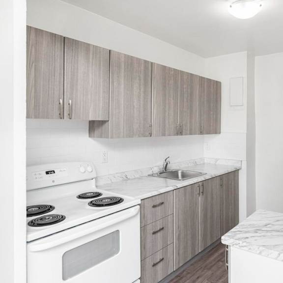 a kitchen with a white stove top oven, white counter top, and white refrigerator.