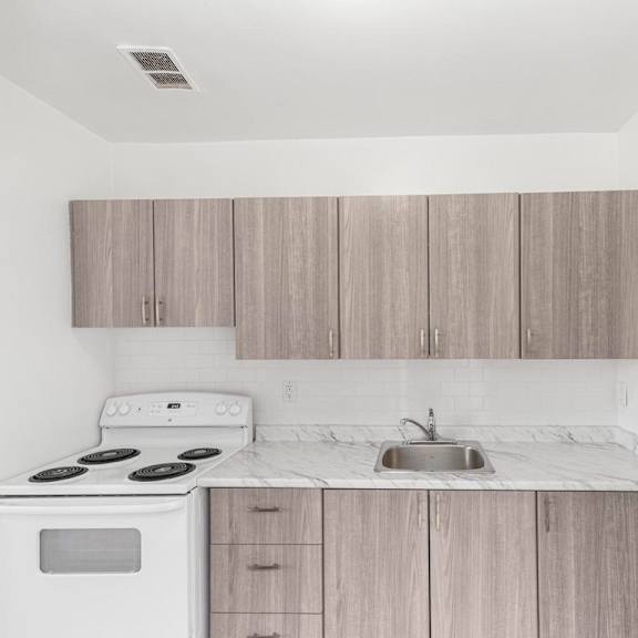 a kitchen with a white stove and wooden cabinets.