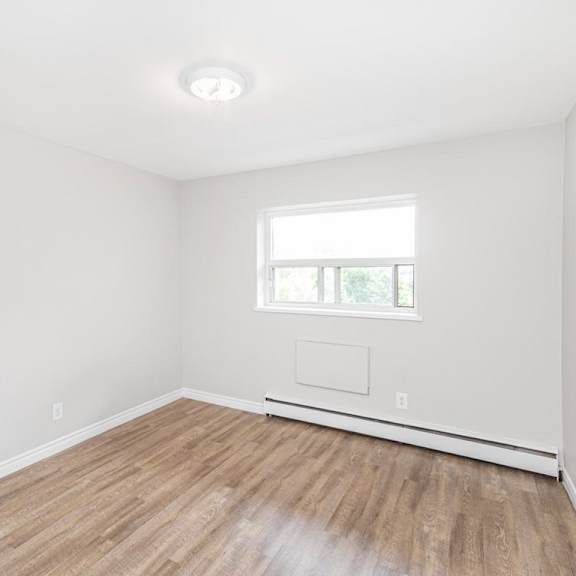 a room with a window and wooden flooring.
