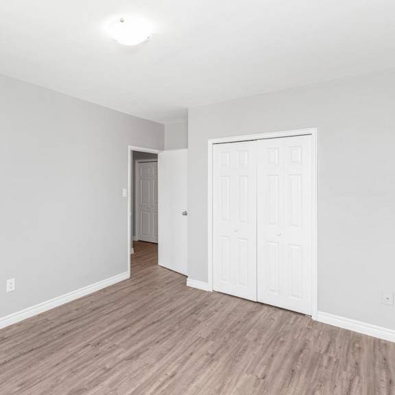 a room with a white door and a brown floor.
