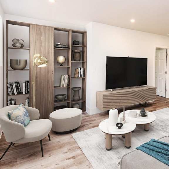 a modern living room with a grey sofa, a white armchair, a wooden bookshelf, a coffee table, and a flat-screen tv.