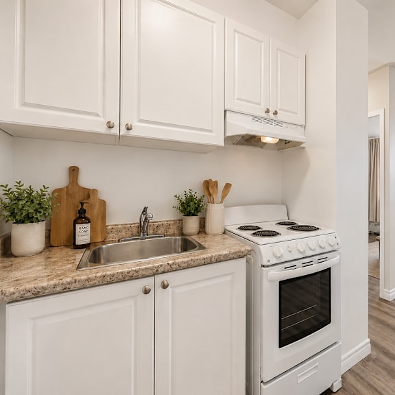 a kitchen with white cabinets and a stove top oven.