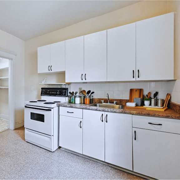 a kitchen with white cabinets and a black stove top oven.